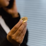 Portrait of a woman holding a Bitcoin, symbolizing digital finance and cryptocurrency trends.
